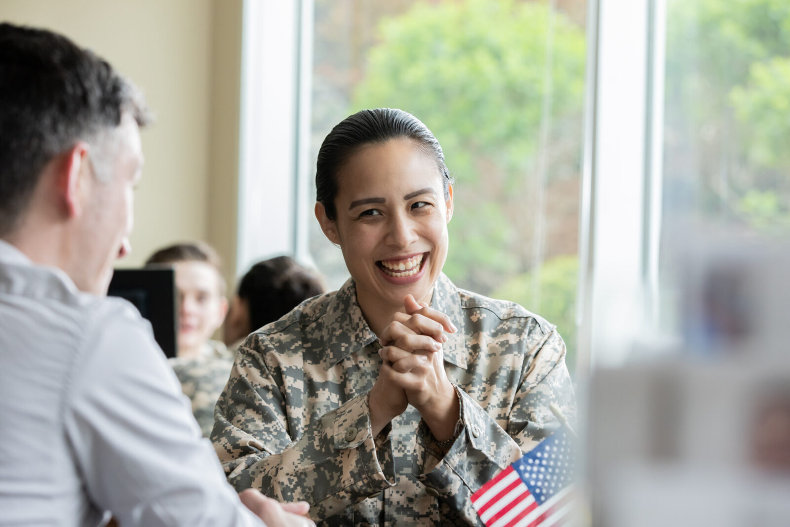 Mature female laughing while speaking with financial planner.